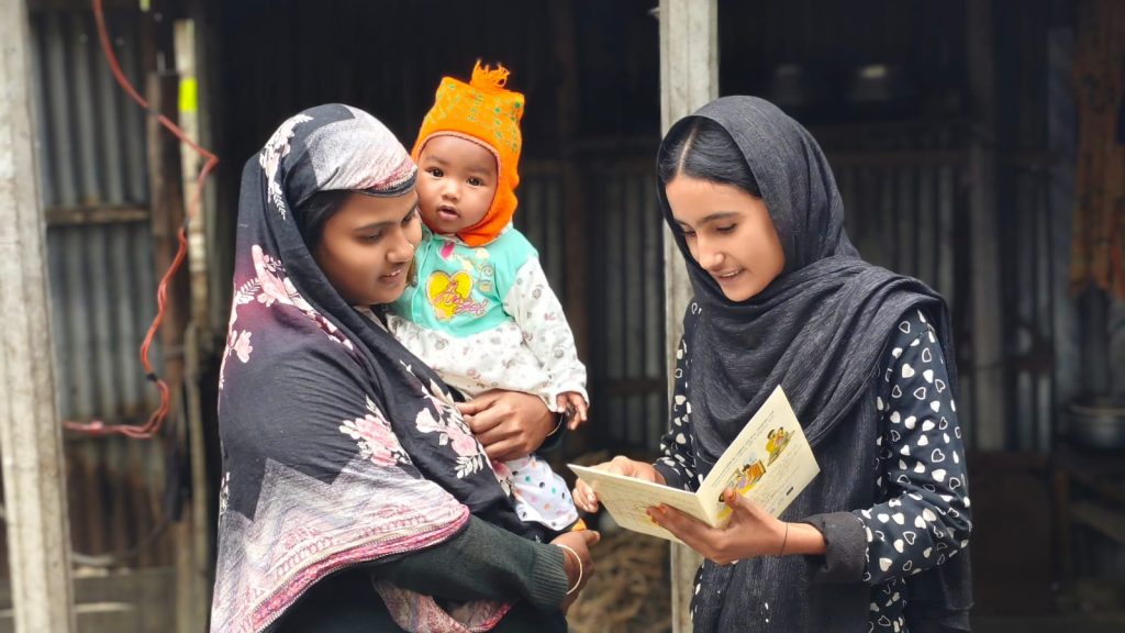 Disha is sharing health-related messages showing a health card to a community member.